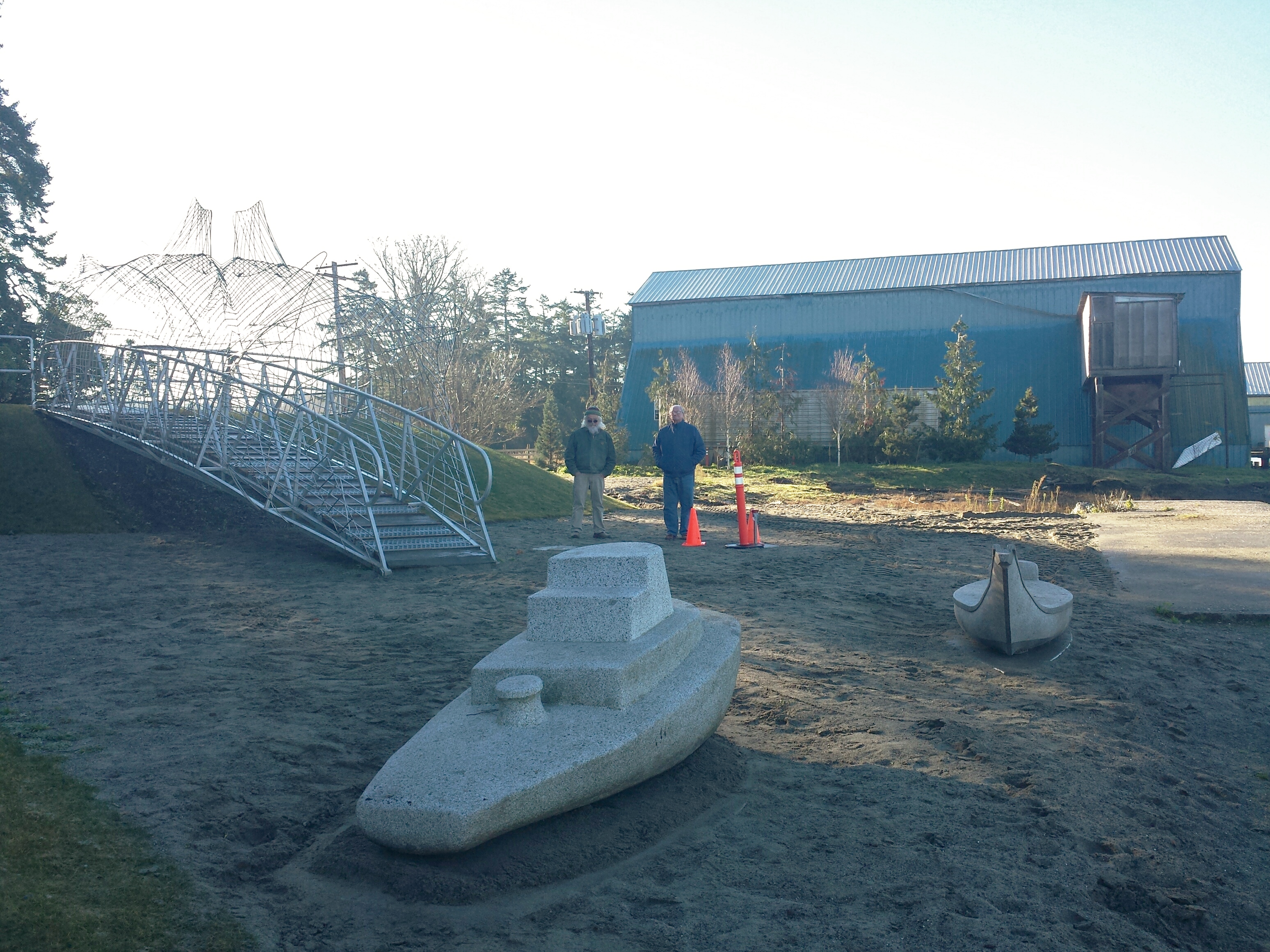 Access to “Crossing Point” is now over and through this pedestrian, stainless steel “Salmon” bridge designed and built by Ries Niemi. Tracy Powel and Oliver (Ollie) Iversen, one of the Park Commissioners, officiating at the relocation site.