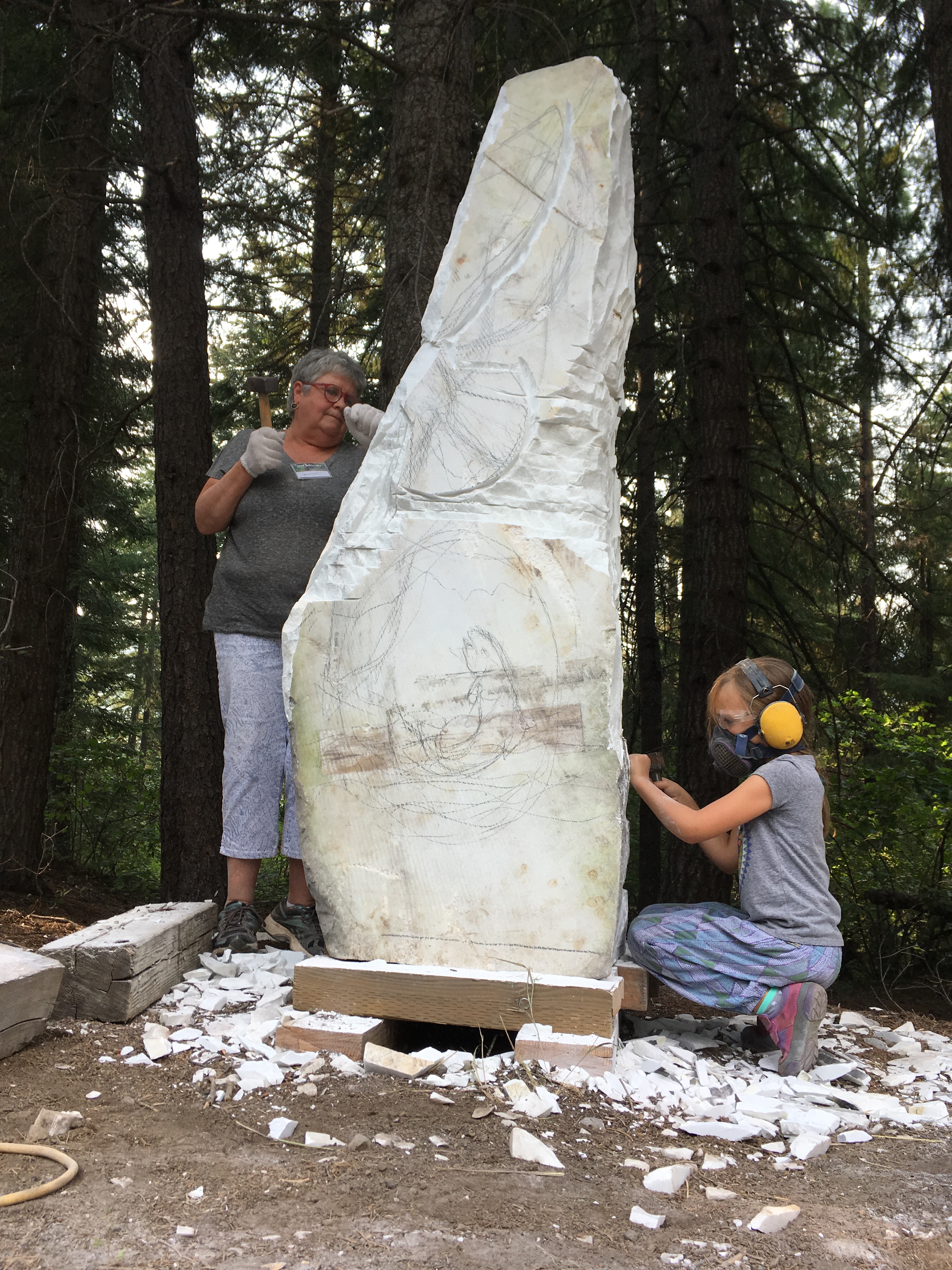Community Stone: Samia Imonen and MJ Anderson carving on the community stone 