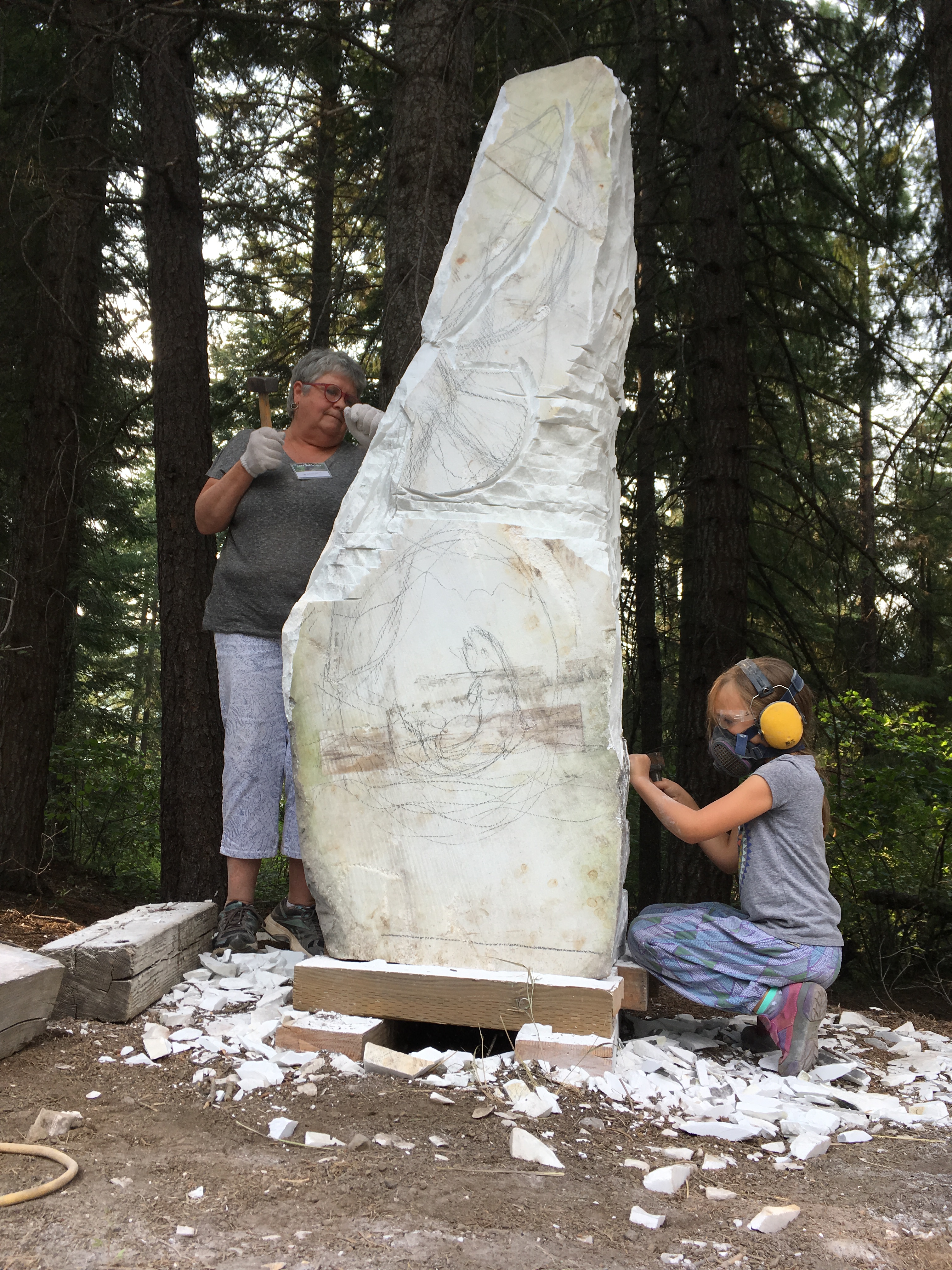 Community Stone: Samia Imonen and MJ Anderson carving on the community stone